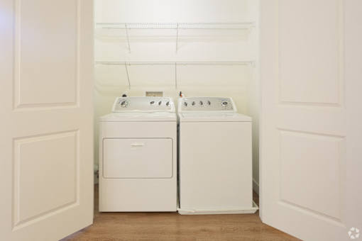 A white laundry room with a washer and dryer.
