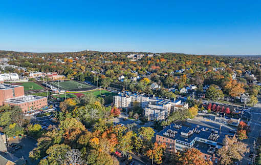 A view of a town with buildings and trees in autumn colors.