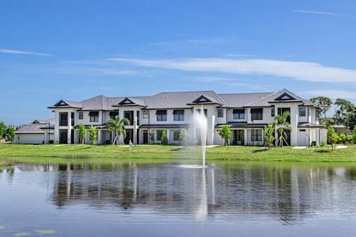 a fountain is in the water in front of a building