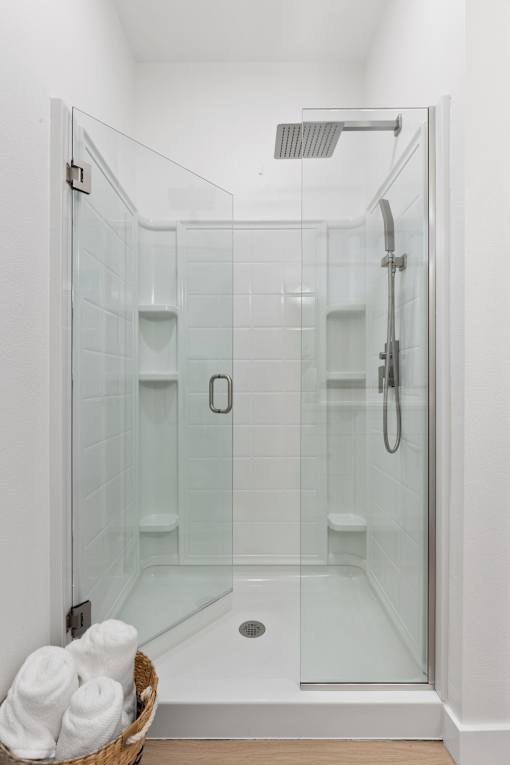 a bathroom with a shower and a basket of towels
