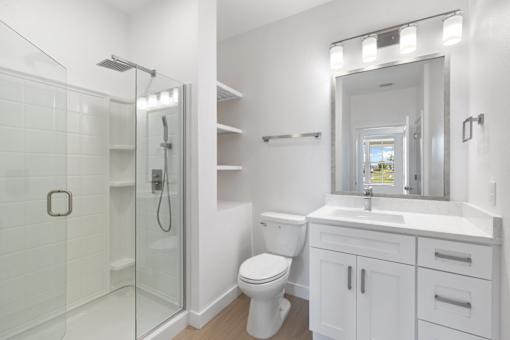 a white bathroom with a shower toilet and sink