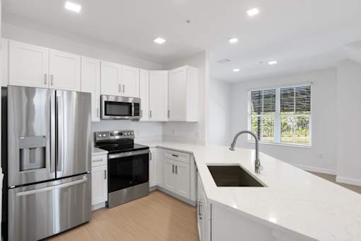 a white kitchen with a sink and a refrigerator
