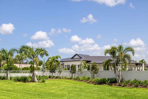the exterior of a house with palm trees in front of it