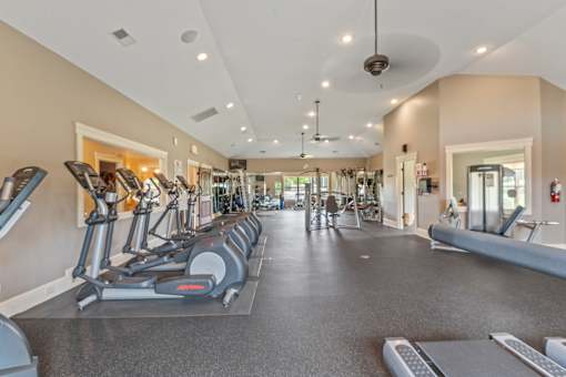 A spacious gym with treadmills, elliptical machines, and other exercise equipment. at The Villas at Nature Walk, Huntsville, Alabama