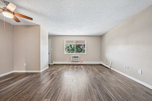 A room with a ceiling fan and wooden flooring.