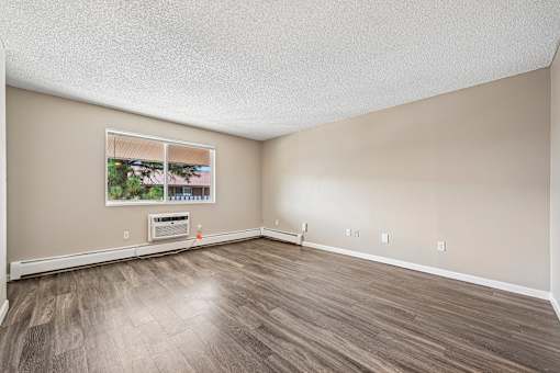 A room with a window and a painting on the wall.