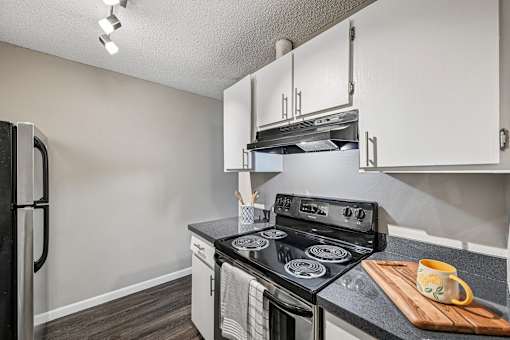 A kitchen with a black stove top oven and a black refrigerator.