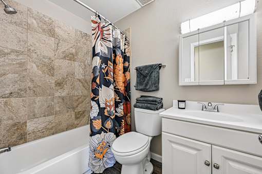 A bathroom with a toilet, sink, and shower.