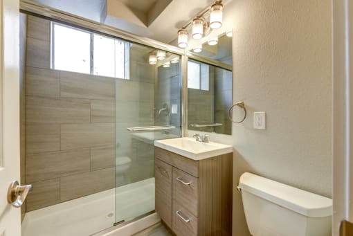 a glass wall in a bathroom with a geometric design on the floor