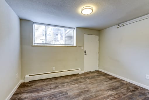 an empty living room with a window and a door