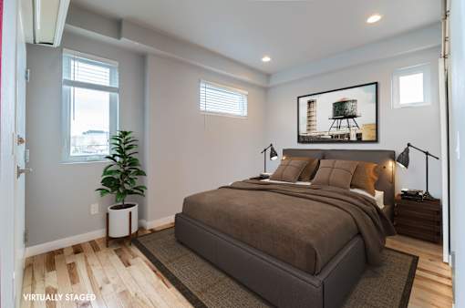 A bedroom with a large bed and a painting on the wall.