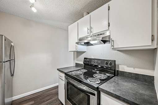 A kitchen with a stove and a refrigerator.