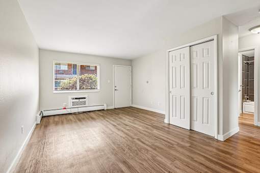 A room with wood flooring and white walls.