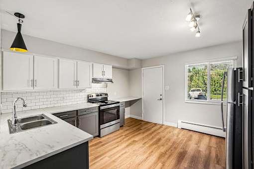 A kitchen with a marble countertop and stainless steel appliances.
