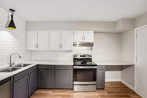 A kitchen with a stove top oven and a sink.