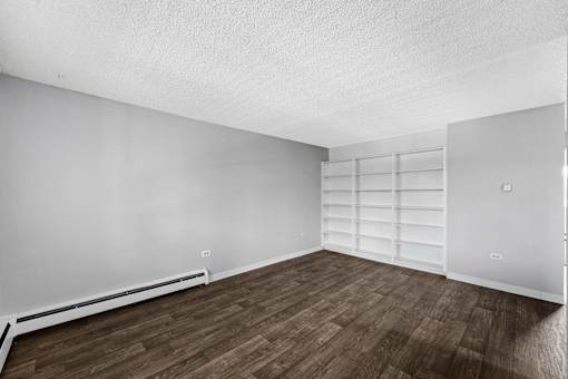 A room with wooden flooring and white walls.
