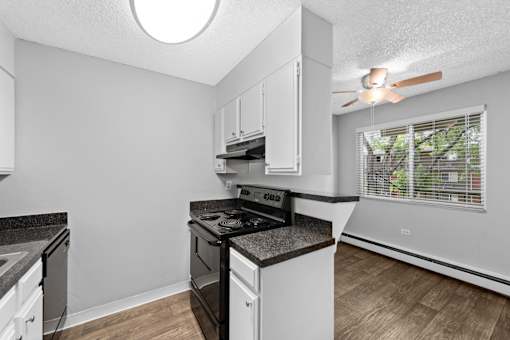 A kitchen with a black stove top oven and white cabinets.