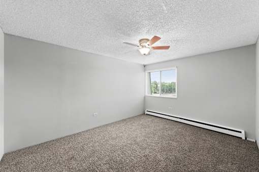 A room with a ceiling fan and a window.