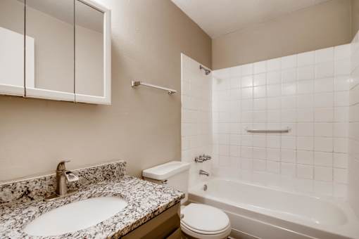 A bathroom with a sink, toilet, and bathtub.