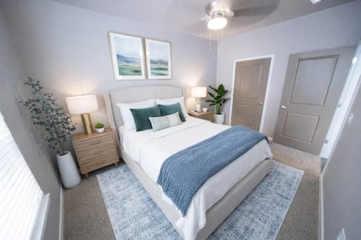 A bedroom with a bed, nightstand, and two framed pictures on the wall.