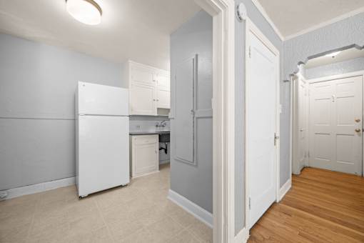 A kitchen with a white fridge and cabinets.