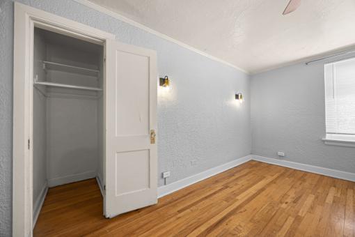 A room with a white door and wooden floors.