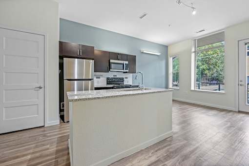 A kitchen with a white countertop and stainless steel appliances. at B Street Lohi Apartments, Colorado