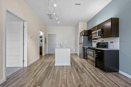 A kitchen with black appliances and brown cabinets. at B Street Lohi Apartments, Denver, CO