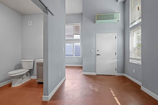 A bathroom with a toilet, sink, and window.