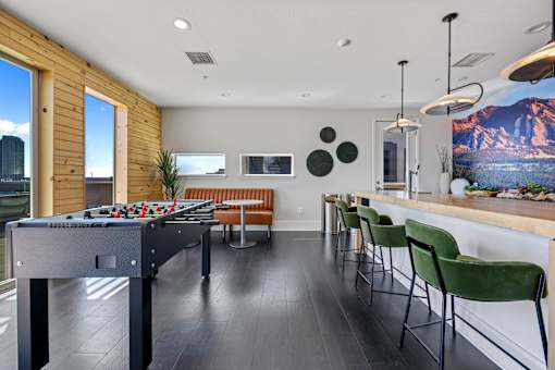 A room with a pool table and a bar area.