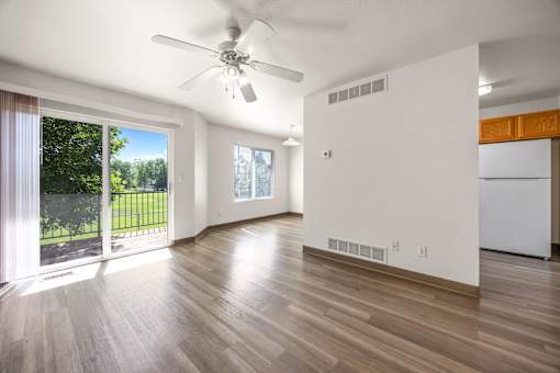 A room with a ceiling fan and wooden flooring.
