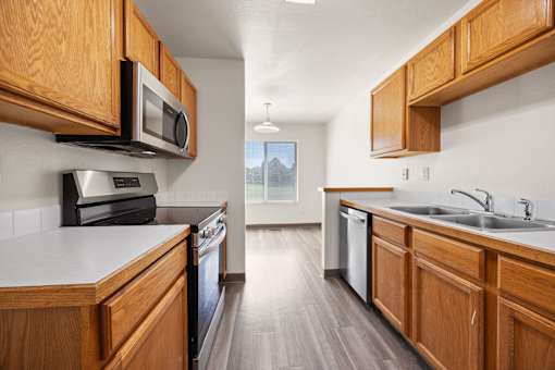 A kitchen with wooden cabinets and a black oven.