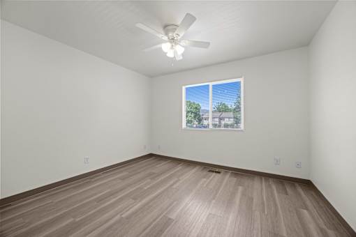 Empty room with a window and a ceiling fan.
