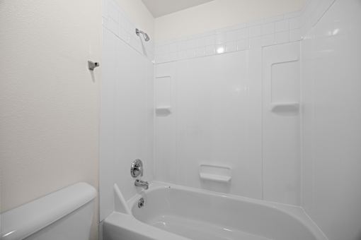 A white bathroom with a tub and shower.