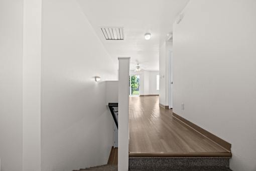 A long hallway with a wooden floor and white walls.