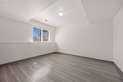 A room with wooden flooring and a window.