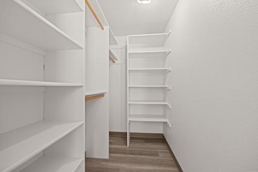 A long hallway with white shelves on the left and a series of steps on the right.