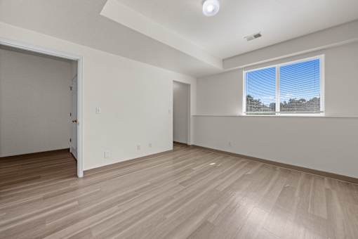 A room with a sliding door and a window with blinds.