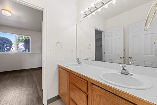 A bathroom with a white counter and a round mirror.
