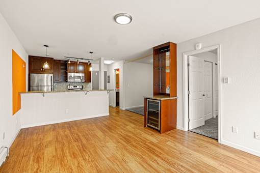 A kitchen with wooden floors and white walls.