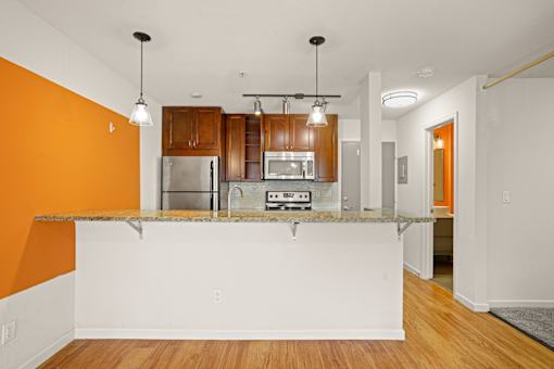 A kitchen with orange walls and a white counter.