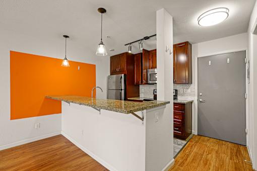 A kitchen with orange wall and white counter.