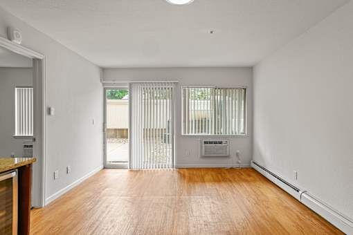 A room with a wooden floor and a sliding glass door.