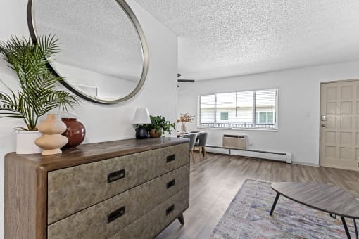 a living room with a dresser and a round mirror
