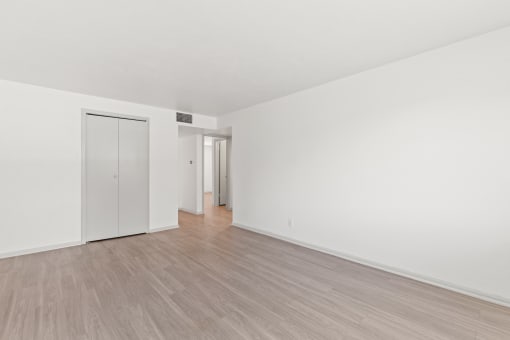 an empty living room with white walls and wood flooring