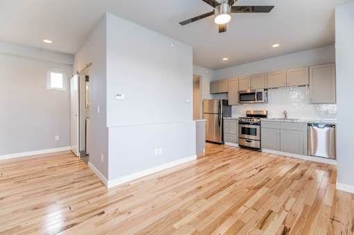 A kitchen with a refrigerator, oven, and microwave.