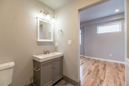 A bathroom with a white sink and a mirror above it.