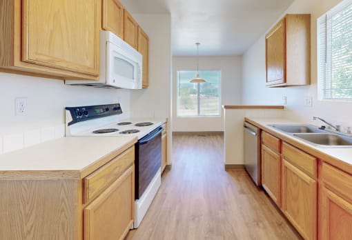 an empty kitchen with wooden cabinets and a stove and a sink