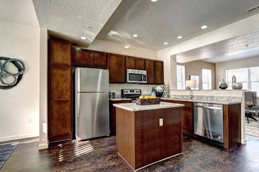 A kitchen with a refrigerator, microwave, and oven.