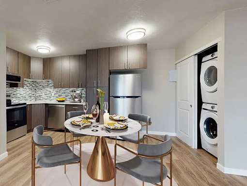 A modern kitchen with a dining table set for two.